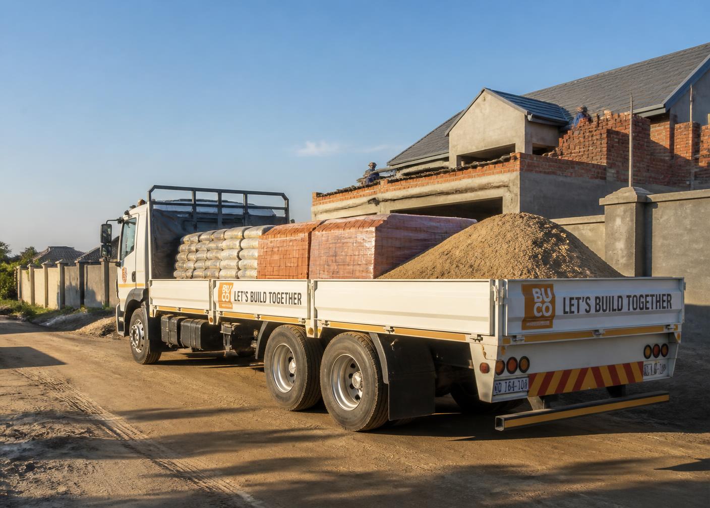 Delivery truck loaded with cement, bricks and sand at a building site